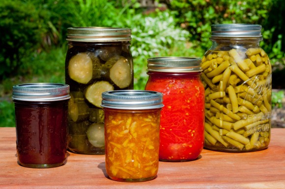 Using best beginner canning tips yields, from left, homemade apple butter, sweet pickles, rose water marmalade, tomatoes, and green beans even on busy days in cramped kitchen quarters. Credit: Susan Lutz