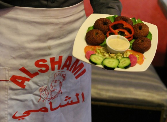 Majdi Al Khdraa, 25, carries an order of Al Shami’s specialty, falafel. Credit: Julie Barstow