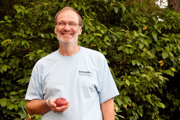 Craig LeHoullier, author of "Epic Tomatoes," holds a Cherokee Purple tomato.  Credit: Susan Lutz