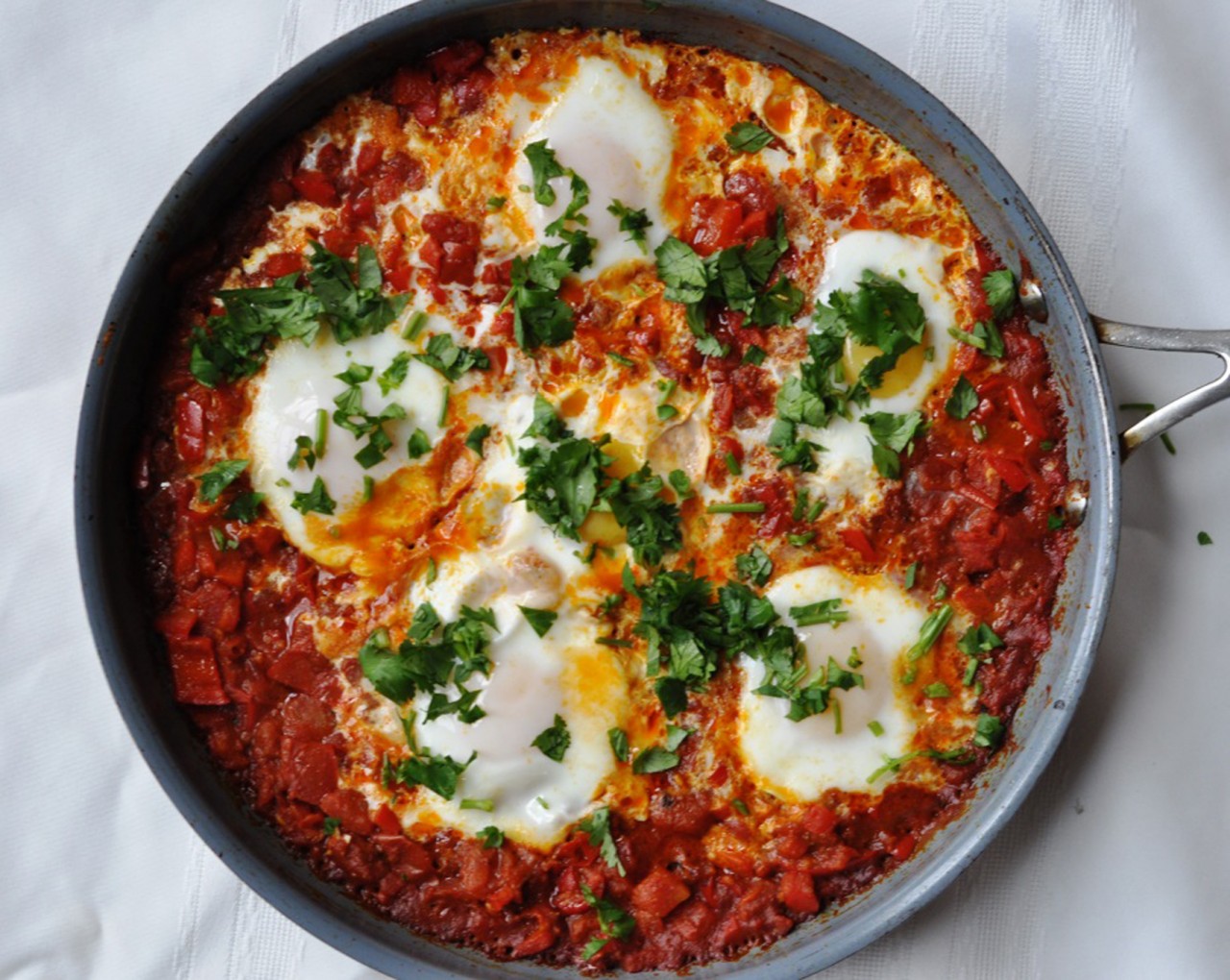 At the heart of shakshouka, a poached egg and spicy tomato dish, is olive oil. Credit: Copyright 2015 Roger Fillion