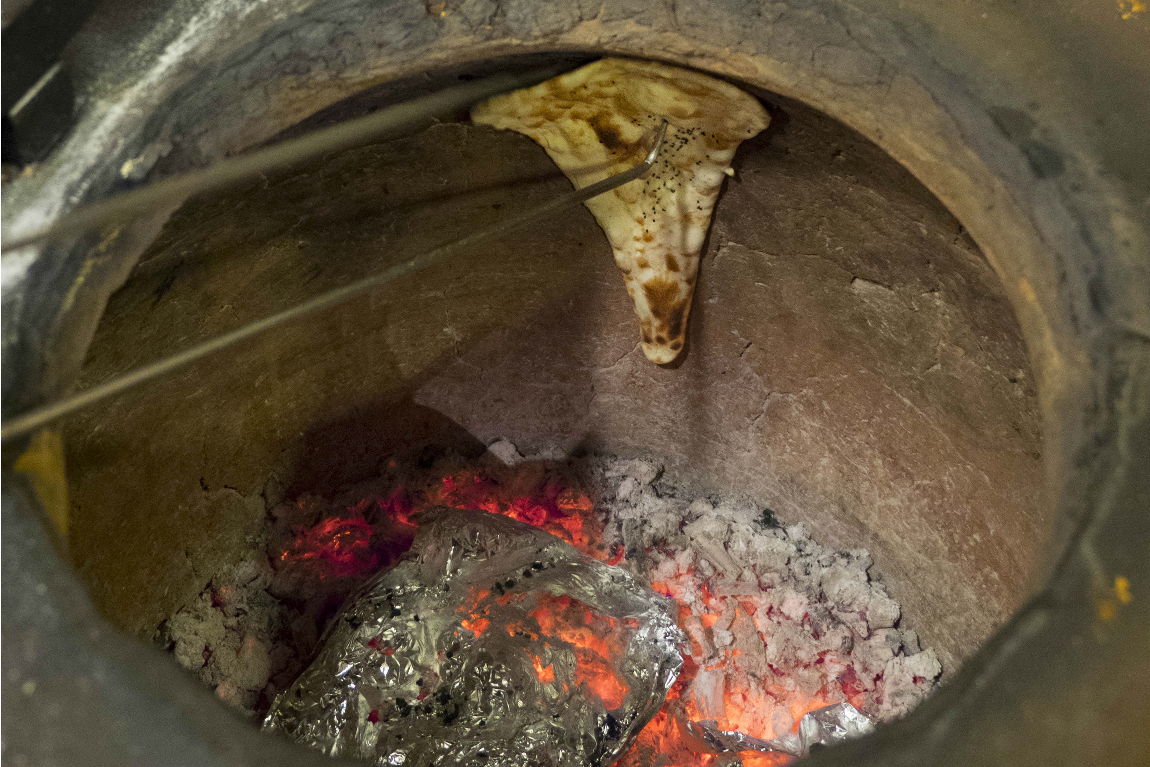 Naan bread bakes in the tandoor oven at Bukhara restaurant. Credit: Copyright 2015 Carla Capalbo