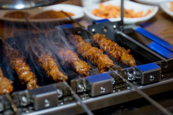 Lamb skewers are cooked at the table at Songhwa Yanggochi near Konkuk University in Seoul. Credit: Copyright 2016 Jo Turner